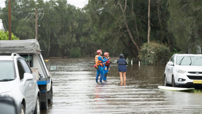 Rescue workers standing in flood waters after a disaster.
